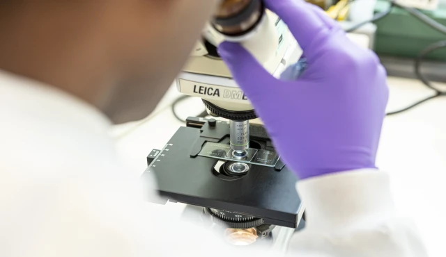 Example of high quality photography for Inspiralis, showing a close up of a scientist using a microscope.